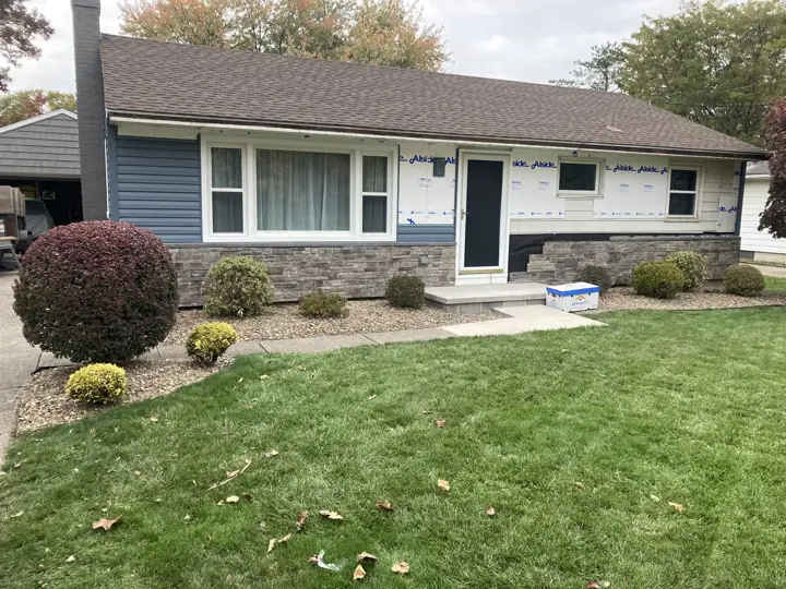 Blue siding and stone exterior during installation